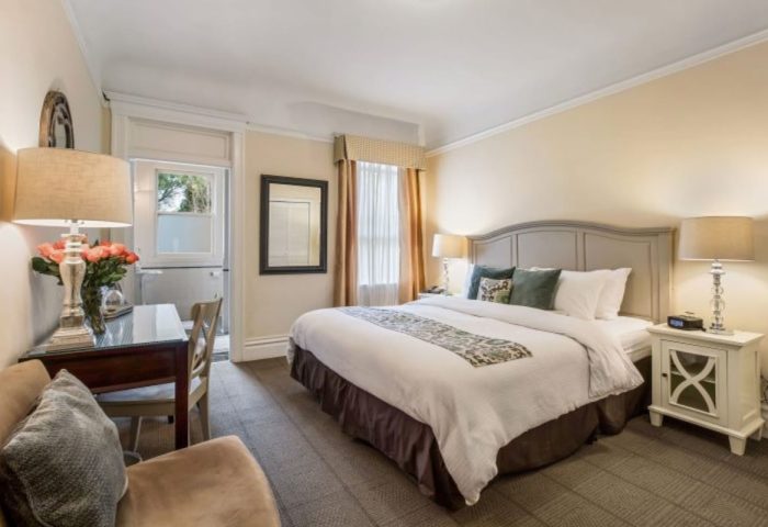 Parker Guest House room. Gay-friendly hotel bedroom with bed, desk, balcony, and nightstand. Comfortable stay for gay men travelers.