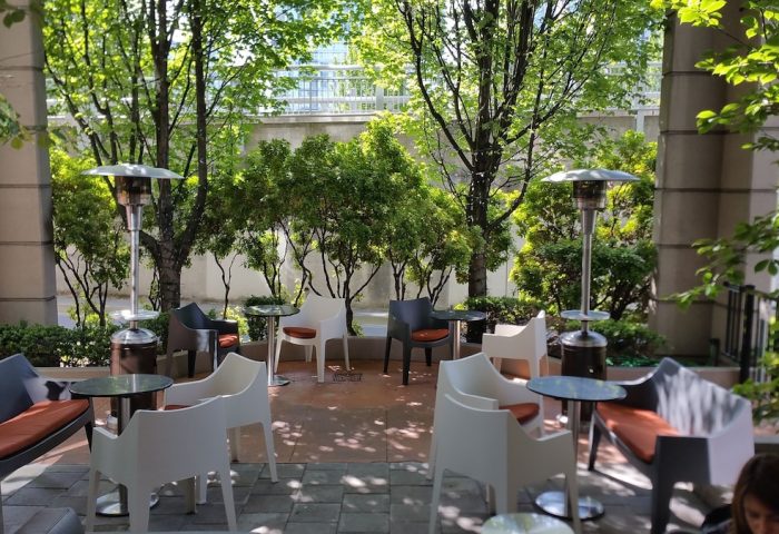 Parker Hotel Vancouver patio. Gay-friendly hotel outdoor seating area with modern chairs, tables, heaters, and lush greenery.