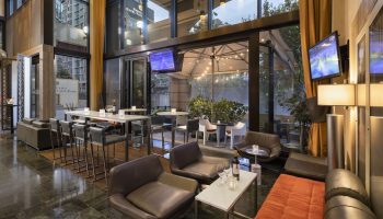 Parker Hotel Vancouver's gay-friendly lounge area with modern seating, tables, and outdoor patio. A great spot for gay men to relax.