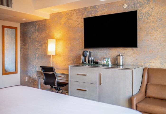 Parker Hotel Vancouver guest room. Desk, chair, TV, and coffee maker. Gay-friendly hotel with modern amenities for comfortable travel.