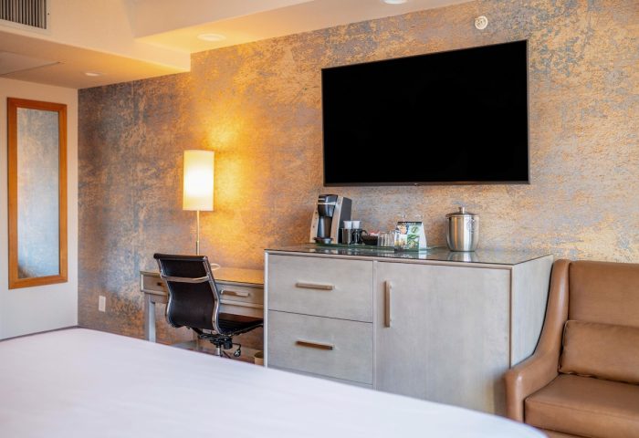 Parker Hotel Vancouver guest room. Desk, chair, TV, and coffee maker. Gay-friendly hotel with modern amenities for comfortable travel.