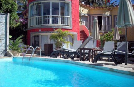 Pasion Tropical Gay Only Resort pool view. Gay-friendly hotel with colorful architecture, sun loungers, and a refreshing pool for gay travelers.