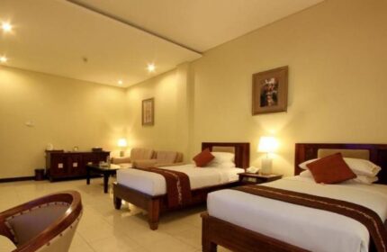 Pelangi Bali Hotel & Spa room. Gay-friendly hotel with twin beds, couch, and warm lighting. Ideal for gay travelers seeking comfort in Bali.