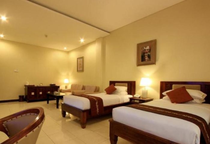 Pelangi Bali Hotel & Spa room. Gay-friendly hotel with twin beds, couch, and warm lighting. Ideal for gay travelers seeking comfort in Bali.