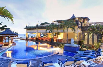 Pelangi Bali Hotel & Spa pool area. Gay-friendly hotel with poolside lounge chairs, restaurant, and ocean view. Bali travel for gay men.
