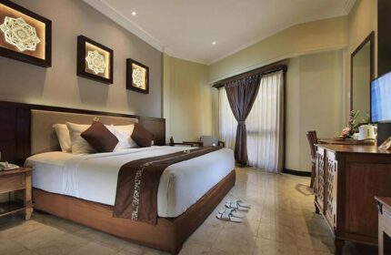 Pelangi Bali Hotel & Spa room. Gay-friendly hotel bedroom with king-size bed, desk, and Balinese art. Relaxing vacation for gay men.