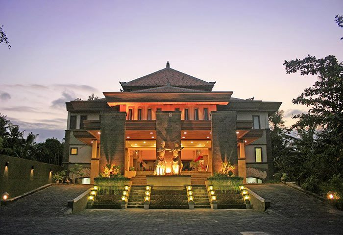 Pelangi Bali Hotel & Spa entrance at dusk. Gay-friendly hotel with traditional Balinese architecture and statues. Great for gay travel in Bali.
