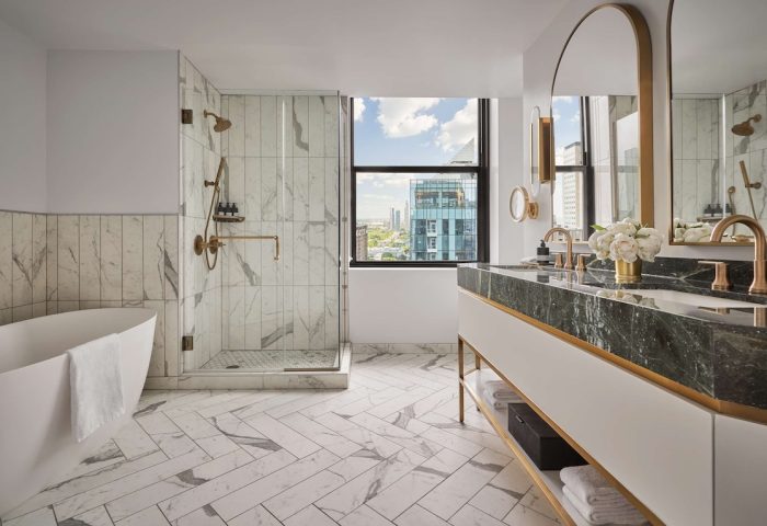Pendry Chicago gay-friendly hotel bathroom. Marble shower, tub, and double vanity. City view. Luxury design for gay men travel.