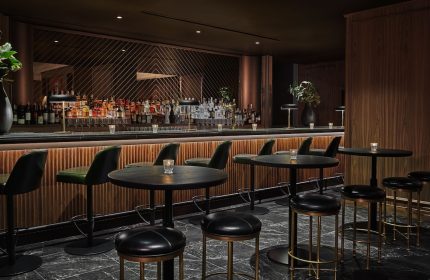 Pendry Chicago gay-friendly hotel bar. Stylish interior with bar stools, tables, and a well-stocked bar. Elegant design for gay travelers.