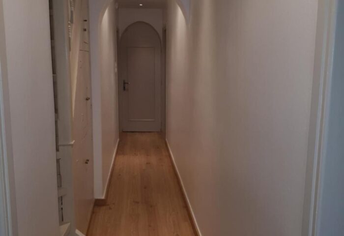Hallway view at Gay-Friendly Hotel Pension Ageliki Kalogera. White walls, wood floor. A welcoming space for gay travelers.