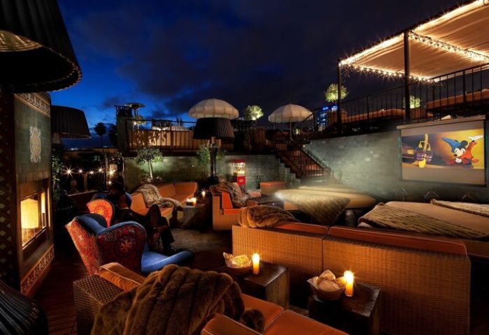 Petit Ermitage Hotel's rooftop cinema. Gay-friendly, adults-only hotel with cozy seating, blankets, and a movie screen under the night sky.
