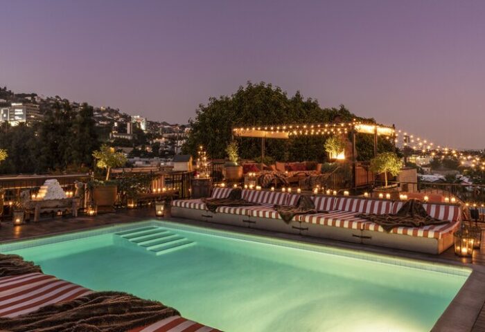 Rooftop pool at Petit Ermitage Hotel, an adults-only, gay-friendly hotel. Night scene with candles, lights, and city views.