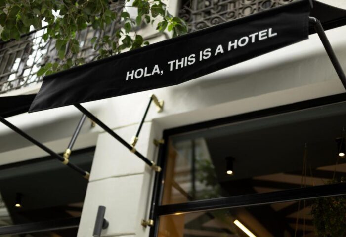 Petit Palace Chueca, a gay-friendly hotel. Awning with Hola, this is a hotel text. A stylish entrance to a welcoming hotel in Chueca.