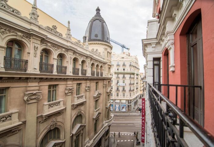 View from Petit Palace Chueca, a gay-friendly hotel. Balcony overlooking Madrid street. Architecture detail. Urban scene.