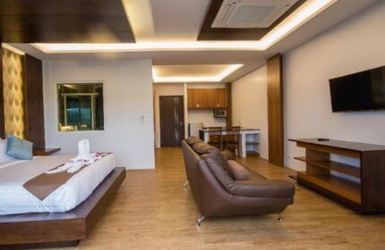 Phi Phi Cliff Beach Resort room. Gay-friendly hotel with bed, couch, TV, kitchenette. Modern design, comfortable for gay travelers.