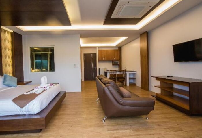 Phi Phi Cliff Beach Resort room. Gay-friendly hotel with bed, couch, TV, kitchenette. Modern design, comfortable for gay travelers.