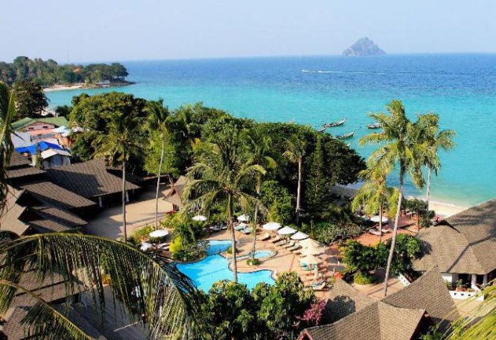 Gay-friendly Phi Phi Holiday Resort aerial view. Tropical beach, pool, and lush greenery. Perfect for gay men's travel to Phi Phi Islands.