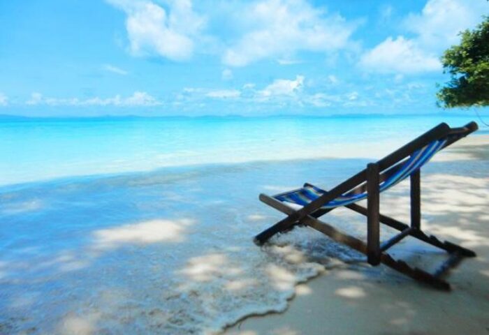 Beach chair at Phi Phi Relax Beach Resort. Gay-friendly hotel with ocean view, white sand, and clear blue water. Perfect for gay travel.