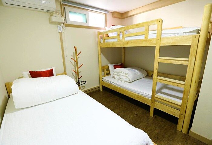 Philstay Itaewon Guesthouse room. Gay-friendly hotel with bunk beds, white linens, and hardwood floors. Budget-friendly accommodation in Seoul.