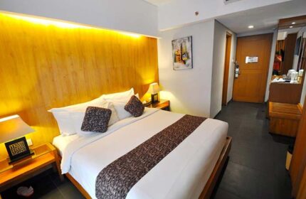 Ping Hotel Seminyak room. Gay-friendly hotel with a bed, bedside tables, lamps, and a painting. Modern design for gay travelers.