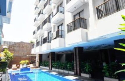 Ping Hotel Seminyak, a gay-friendly hotel. View of the building with balconies and a blue tiled pool. Ideal for gay men's travel in Seminyak.