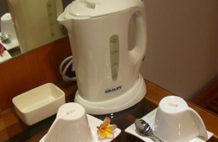 Ping Hotel Seminyak room detail: Kettle, cups, and flower on a table. Gay-friendly hotel room amenities for a comfortable stay in Seminyak.