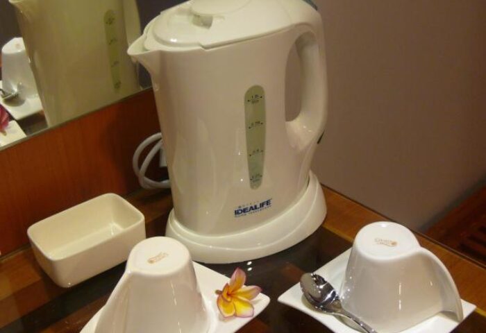 Ping Hotel Seminyak room detail: Kettle, cups, and flower on a table. Gay-friendly hotel room amenities for a comfortable stay in Seminyak.
