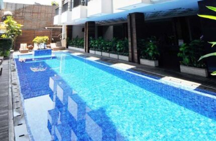 Ping Hotel Seminyak's pool. This gay-friendly hotel in Seminyak features a blue tiled pool with lounge chairs for relaxing poolside.