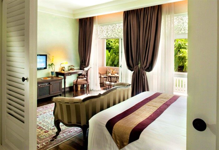 Ping Nakara Boutique Hotel and Spa room. Gay-friendly hotel with bed, desk, and balcony. Chiang Mai luxury accommodation for gay travelers.