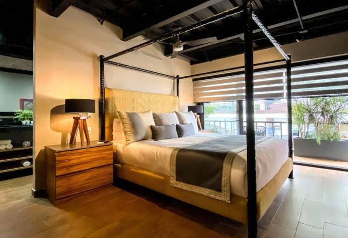 Pinnacle Resorts 179 Adults Only gay-friendly hotel room. Four-poster bed, modern design, balcony view. Ideal for gay travel.