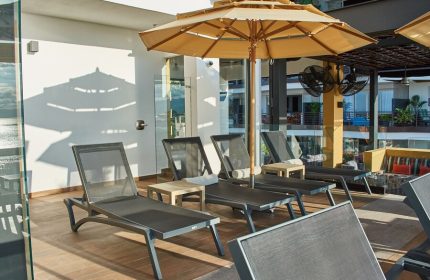 Pinnacle Resorts 179 Adults Only, gay-friendly hotel. Poolside lounge chairs with umbrellas for relaxing in the sun at this gay resort.
