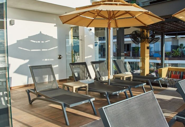 Pinnacle Resorts 179 Adults Only, gay-friendly hotel. Poolside lounge chairs with umbrellas for relaxing in the sun at this gay resort.