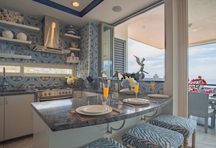 Pinnacle Resorts 180 gay-friendly hotel kitchen. Blue and white tile, granite countertops, and zebra-print stools. Ocean view.