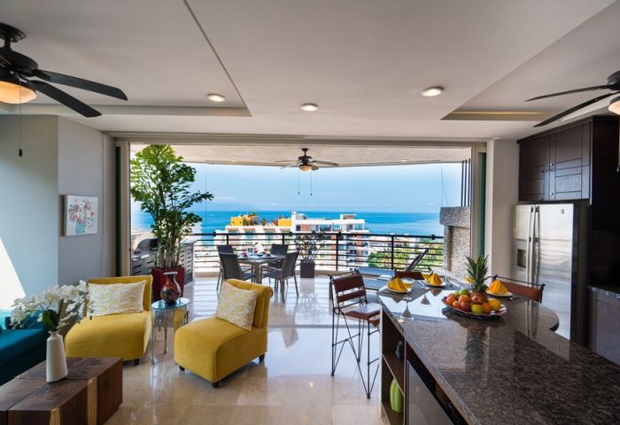 Pinnacle Resorts 180 gay-friendly hotel suite. Living space with balcony ocean view. Upscale kitchen, seating, & modern design. Puerto Vallarta.