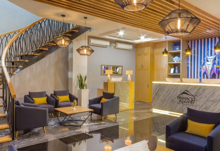 Pinnacle Resorts 180 lobby. Gay-friendly hotel interior with seating area, reception desk, modern lighting, and staircase. Upscale design.