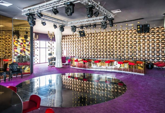 Platinum Yucatan Princess Adults Only Resort bar area. Gay-friendly all-inclusive suites and spa hotel with modern decor, red stools, and stage lighting.