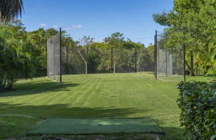 Gay-friendly Platinum Yucatan Princess All Inclusive Resort adults-only golf practice area. Lush green grass and netting. Ideal for gay travel.