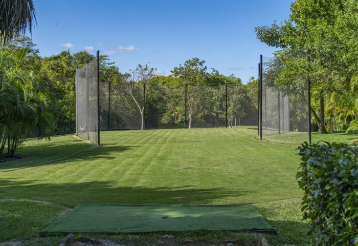 Gay-friendly Platinum Yucatan Princess All Inclusive Resort adults-only golf practice area. Lush green grass and netting. Ideal for gay travel.