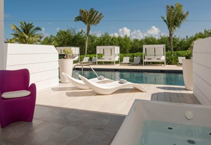 Platinum Yucatan Princess All Inclusive Suites and Spa Resort Adults Only gay-friendly hotel. Poolside view with lounge chairs and jacuzzi.