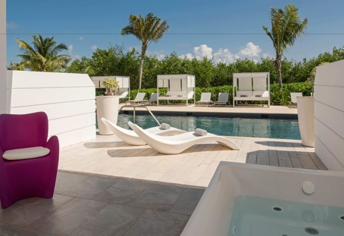Platinum Yucatan Princess All Inclusive Suites and Spa Resort Adults Only gay-friendly hotel. Poolside view with lounge chairs and jacuzzi.
