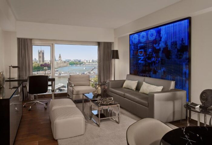 Park Plaza London Riverbank gay-friendly hotel room. Interior view with sofa, desk, and view of Houses of Parliament. Pet-friendly.