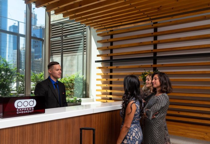 Pod Times Square hotel reception. Guests check in at this gay-friendly hotel in NYC. Modern design, wood accents, and friendly staff.