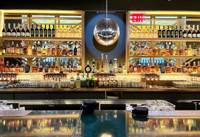 Bar at gay-friendly Pod Times Square Hotel. Shelves of liquor bottles, glassware, disco ball. Great spot for gay men travelers.