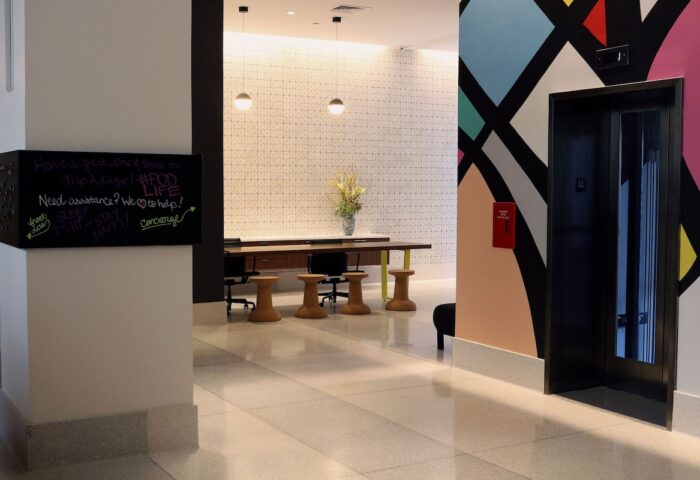 Pod Times Square's stylish lobby. A gay-friendly hotel with modern design, featuring a chalkboard with guest messages and colorful wall art.