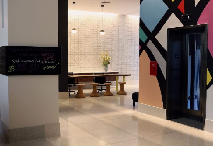 Pod Times Square's stylish lobby. A gay-friendly hotel with modern design, featuring a chalkboard with guest messages and colorful wall art.