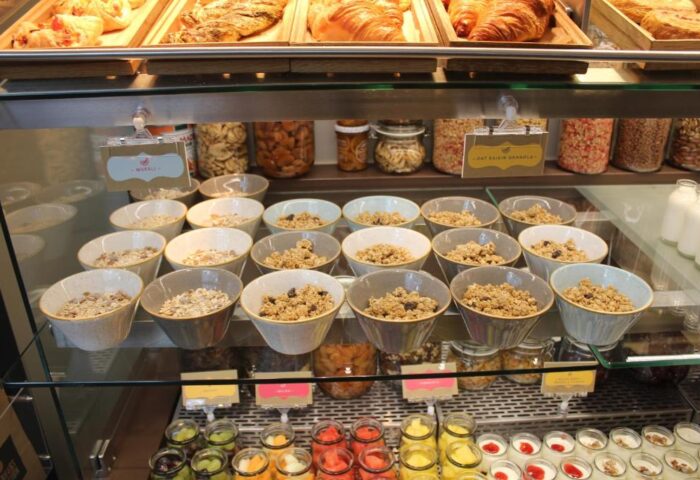 Breakfast buffet at Point A Hotel London Shoreditch. Croissants, cereal, granola, fruit, and yogurt. Gay-friendly hotel breakfast selection.
