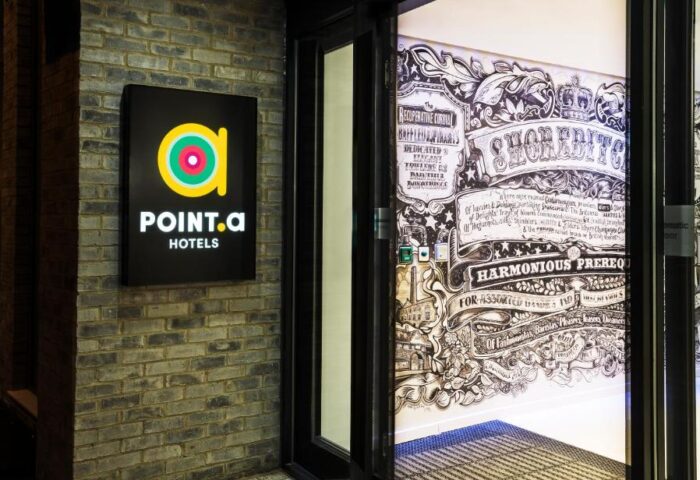 Point A Hotel London Shoreditch entrance. The gay-friendly hotel's sign is on the left, with a mural visible through the open doorway.