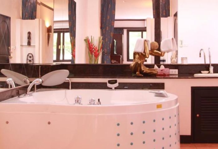 Poseidon Boutique Hotel gay-friendly room. Large jacuzzi tub with a statue holding towels. Gay travel luxury accommodation.