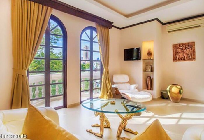 Poseidon Boutique Hotel junior suite. Gay-friendly hotel room with balcony, city view, glass table, and modern decor. Luxury gay travel.