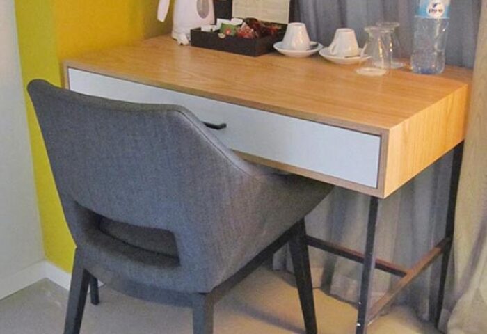 Prima City Tel Aviv Hotel room desk. Gay-friendly hotel room detail with chair, desk, water bottle, coffee cups, and tea.